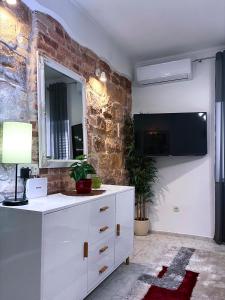 a white dresser in a room with a brick wall at Apartment Vitturina in Kaštela