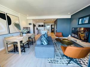 Una sala de estar con un sofá azul y una mesa. en Urban Elephant 16 On Bree, en Ciudad del Cabo
