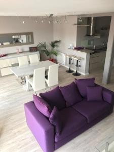 a living room with a purple couch and a kitchen at Appartement ST JEAN Centre Ville Wifi Balcon Parking in Saint-Jean-de-Monts