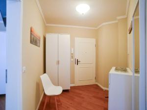 Zimmer mit einem weißen Stuhl und einer weißen Tür in der Unterkunft Dünenpark Binz - Komfortplus Ferienwohnung mit 2 Schlafzimmern und Terrasse 187 in Binz