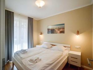 ein Schlafzimmer mit einem Bett mit zwei Handtüchern darauf in der Unterkunft Dünenpark Binz - Komfortplus Ferienwohnung mit 2 Schlafzimmern und Terrasse 187 in Binz