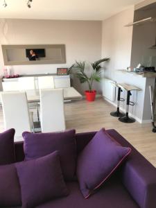 sala de estar con sofá púrpura y mesa en APPARTEMENT Résidence GARDENIAS SAINT JEAN DE MONTS, en Saint-Jean-de-Monts