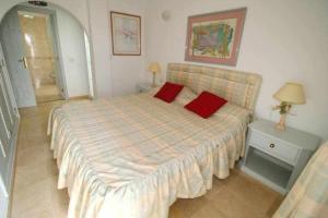 1 dormitorio con 1 cama grande y 2 almohadas rojas en Callao Salvaje Villa15 by Tenerife Rental and Sales, en Callao Salvaje