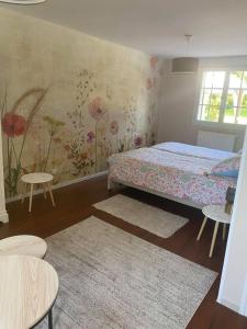 a bedroom with a bed and a floral wall at Le Torcopel in Grangues