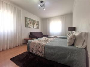 um quarto com uma cama e uma sala de estar em Anamar na Nazaré