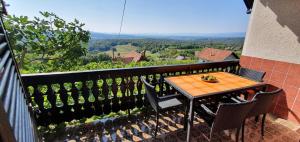 een tafel en stoelen op een balkon met uitzicht bij Vineyard Holidays Cottage with Jacuzzi in Metlika