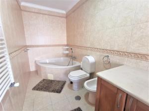 Un baño con inodoro, bañera y lavabo. en Anamar, en Nazaré