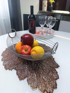 a bowl of fruit on a table with wine glasses at Apartment Vitturina in Kaštela
