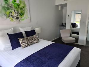 a bedroom with a bed with blue and white pillows at The Avenue Inn in Naracoorte +22 photos