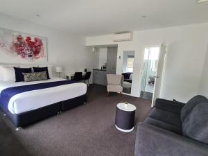 a hotel room with a bed and a couch at The Avenue Inn in Naracoorte