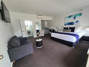 a hotel room with a bed and a couch at The Avenue Inn in Naracoorte