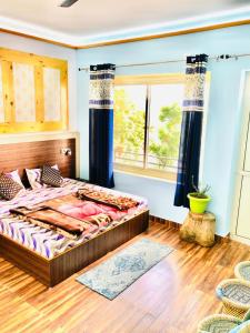 - une chambre avec un lit et une grande fenêtre dans l'établissement Paradise Inn Boutique Resort by HBR, à Dharamsala