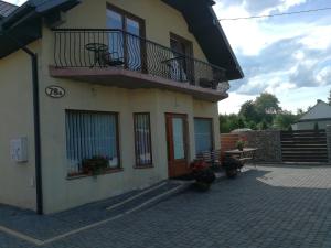 Pensjonat Pod Tetrapodem في Zagnańsk: منزل مع شرفة وطاولة مع الزهور