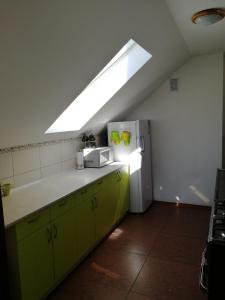 a kitchen with a skylight and a refrigerator at Pensjonat Pod Tetrapodem in Zagnańsk