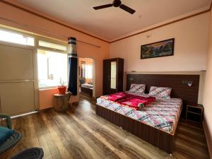 Schlafzimmer mit einem Bett und einem Deckenventilator in der Unterkunft Paradise Inn Boutique Resort by HBR in Dharamsala