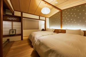 1 Schlafzimmer mit 2 Betten und einem Fenster in der Unterkunft Gion Shirakawa no Yado by YADORU KYOTO HANARE in Kyoto