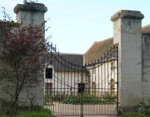 Ferme du bois de Veude في Anché: بوابه لمبنى به عماره