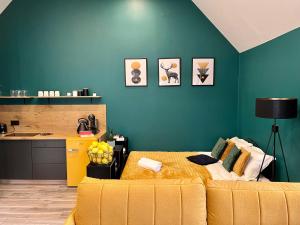 a bedroom with a yellow bed and a green wall at MK Hornik Apartament in Kowary