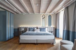 a bedroom with a large bed with blue pillows at Relais Balcone di Giulietta in Verona