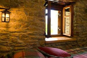 a bedroom with a window in a stone wall at The House of Prince in Nea Stira