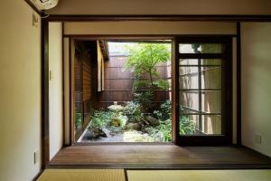 una puerta abierta a un jardín fuera de una casa en Tachibana an by YADORU KYOTO HANARE en Kioto