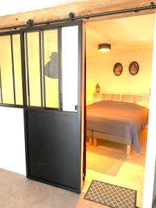 a bedroom with a bed and a sliding glass door at Le Laurier in Vouvray