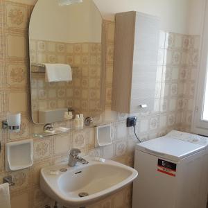 y baño con lavabo y espejo. en Appartamento 6 posti, con balconi vista mare en Rímini