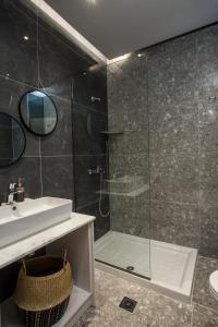 een badkamer met een douche, een wastafel en een spiegel bij GM Apartments-Rhodes Luxury Living in Kalithies