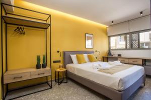 a bedroom with a large bed and a yellow wall at GM Apartments-Rhodes Luxury Living in Kalithies