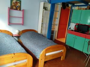 Habitación con 2 camas, armarios verdes y TV. en 2 Gîtes à Fleury les aubrais 1 studio ou 1 gîte, en Fleury-les-Aubrais