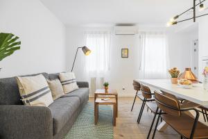 uma sala de estar com um sofá e uma mesa em Vallecano Apartments by Olala Homes em Madrid