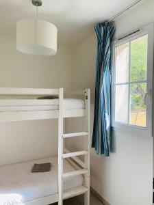 1 dormitorio con 2 literas y ventana en Les Maisons du Golf de la Cabre d'Or by Ateya Vacances, en Cabriès