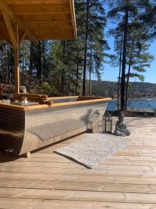Summer cabin in Nesodden open-air bath large terrace في Brevik: سطح خشبي مع حوض استحمام فوق طاولة