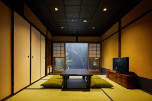 京都的住宿－Kyoto Urushiro Wakasaya by YADORU KYOTO HANARE，客房设有桌子和大窗户。
