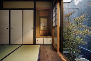 una stanza con porte scorrevoli in vetro e una pianta di Kyoto Urushiro Wakasaya by YADORU KYOTO HANARE a Kyoto