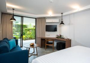 a living room filled with furniture and a tv at Dewa Phuket Resort & Villas - SHA Extra Plus in Nai Yang Beach