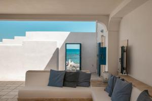 a couch in a room with a view of the ocean at La Porta del Mare in Villanova di Ostuni