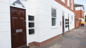 uma porta do lado de um edifício em Modern Contractors & Family Apartment - Central Location inc Private Parking em Bedford