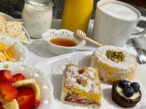 a table topped with plates of pastries and fruit at B&B Mare Monti Miniere in Iglesias +33 photos