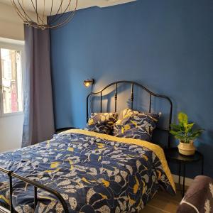 - une chambre bleue dotée d'un lit avec un mur bleu dans l'établissement Joli T4 rénové climatisé entre St Charles/le Vieux-port, à Marseille