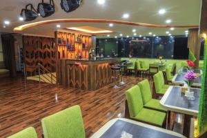 a restaurant with green chairs and a bar at Greenery View Point Resort in Kathmandu