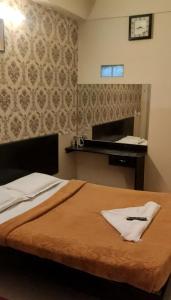 pokój hotelowy z łóżkiem ze stołem i odwrotnością w obiekcie Raj Residency Mysuru w mieście Mysuru