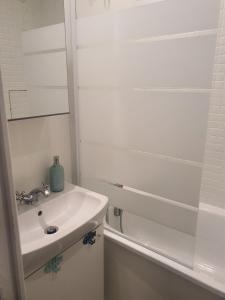 een witte badkamer met een wastafel en een douche bij Côté Ré in Saint-Martin-de-Ré