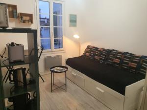 een kleine slaapkamer met een bed en een raam bij Côté Ré in Saint-Martin-de-Ré