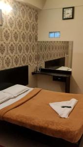 A bed or beds in a room at Raj Residency Mysuru