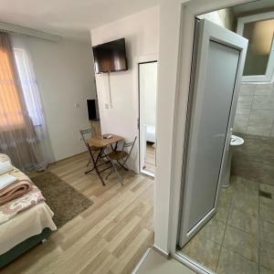 een kamer met een bed, een tafel en een spiegel bij Venecia Plaza Struga in Struga