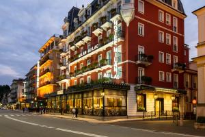 Un alto edificio rosso su una strada cittadina di Hotel Milan Speranza Au Lac a Stresa