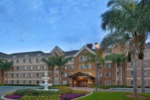 a large building with palm trees and a fountain at Sonesta ES Suites San Diego - Sorrento Mesa in Sorrento