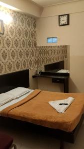 A bed or beds in a room at Raj Residency Mysuru