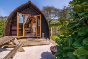 een klein houten huisje met een houten terras en een tafel bij Humble Bee Farm Glamping in Folkton